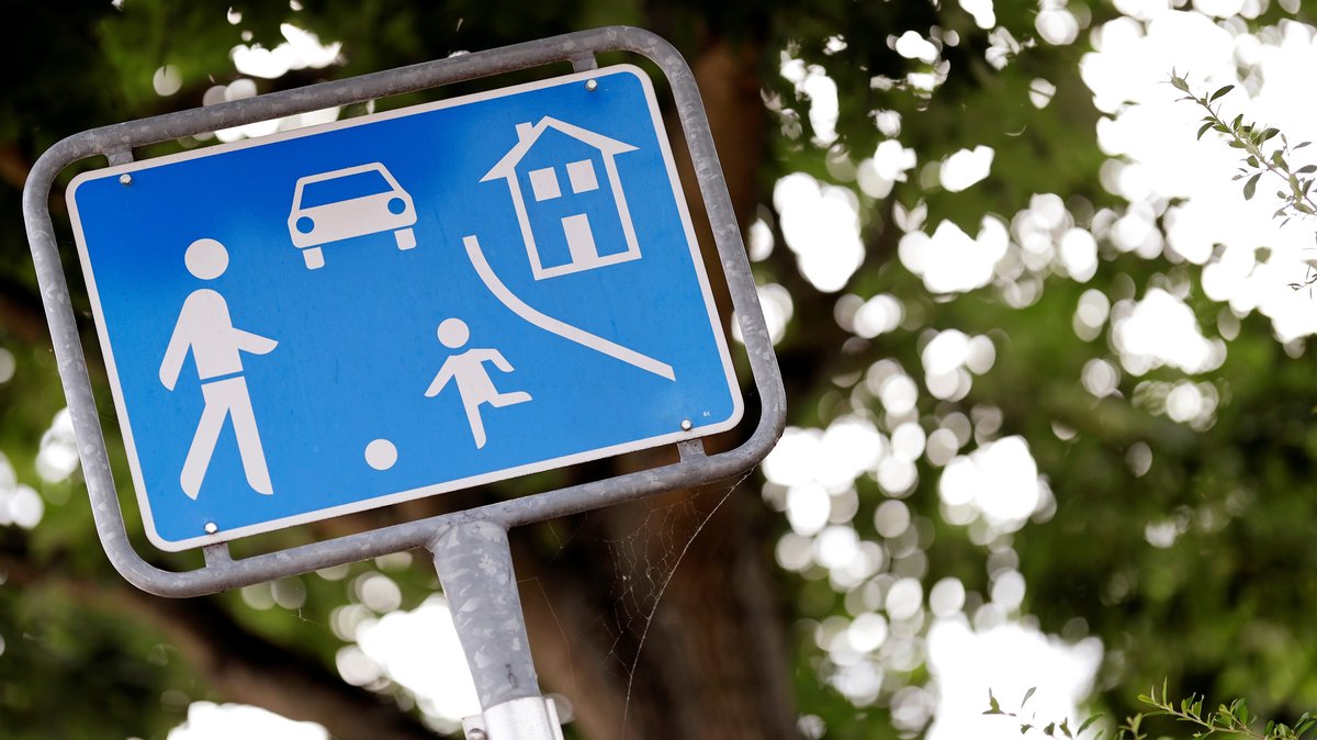 Das typische blaue Schild Verkehrszeichen 325.1 weist auf eine verkehrsberuhigte Zone, auch Spielstraße genannt, hin. Hier ist die Geschwindigkeit der Autos auf Schritttempo zu reduzieren, laut Gesetzgeber vier bis sieben Stundenkilometer. 