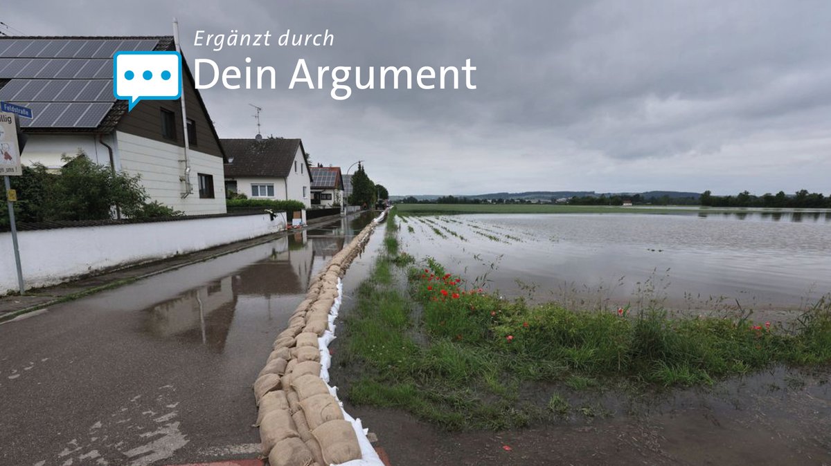 03.06.2024, Bayern, Asbach-Bäumenheim: Eine Barriere mit Sandsäcken soll ein Wohngebiet vor dem Hochwasser schützen.