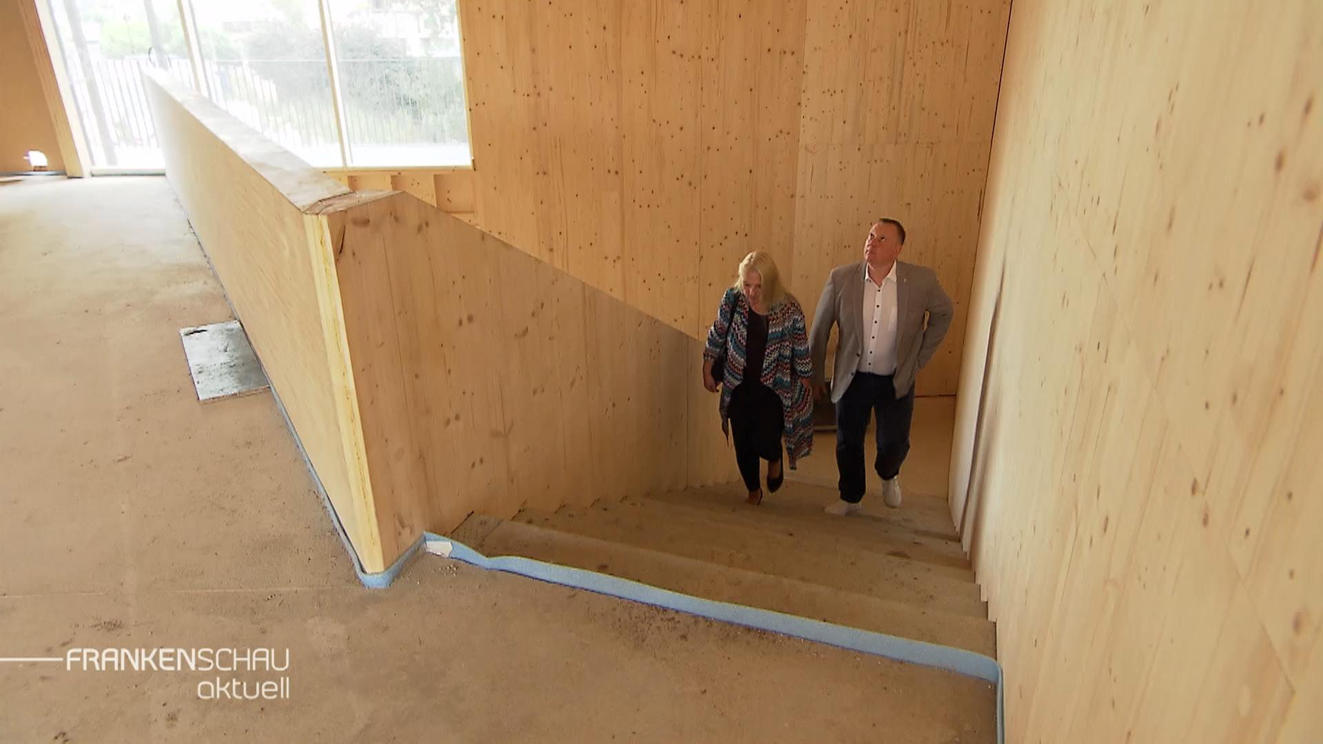 Zwei Menschen in einer Hausbaustelle.