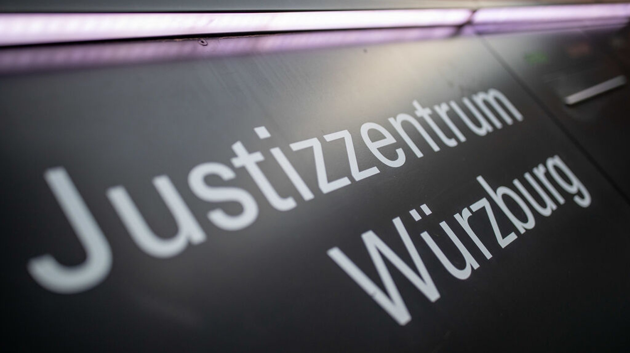 ARCHIV - 05.03.2020, Bayern, Würzburg: «Justizzentrum Würzburg» steht auf einem Schild im Eingangsbereich zum Landgericht. (zu dpa: «Mann vor Club getötet - Angeklagter kommt aus U-Haft frei») Foto: Daniel Karmann/dpa +++ dpa-Bildfunk +++