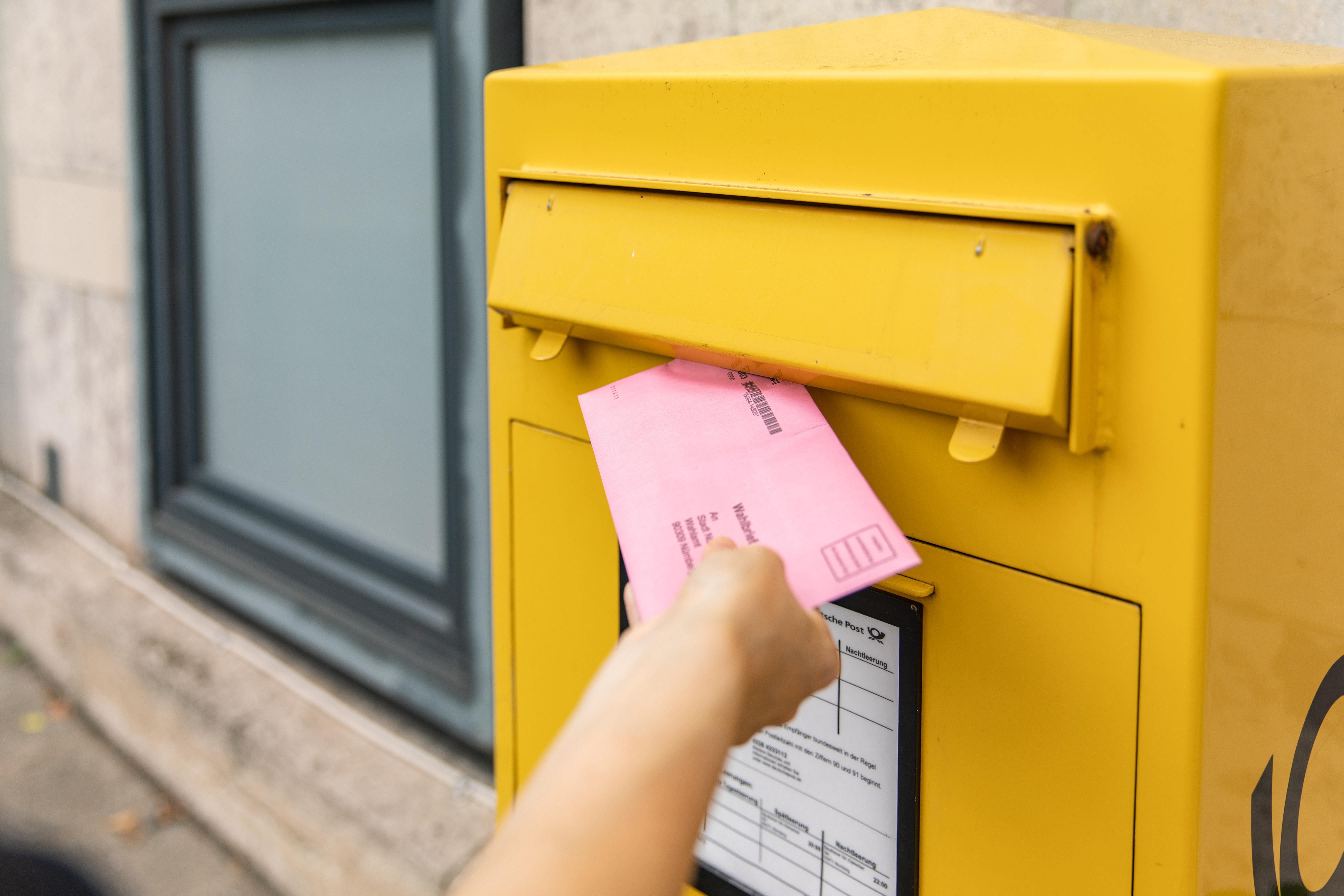 Ein Briefwahlumschlag wird in den Briefkasten geworfen
