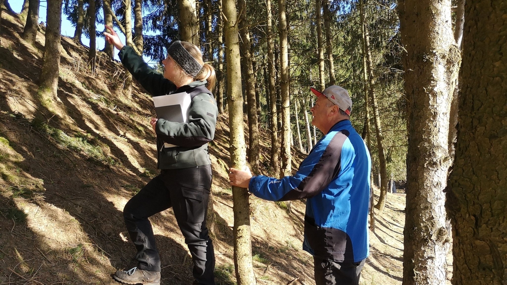 Försterin mit Waldbesitzer im Wald.