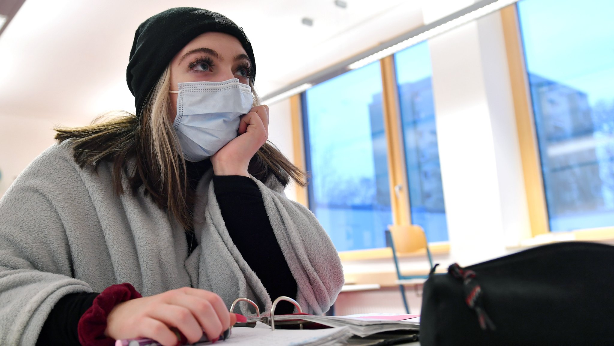 Studentin in dickem Pulli und mit Corona-Schutzmaske (Symbolbild)