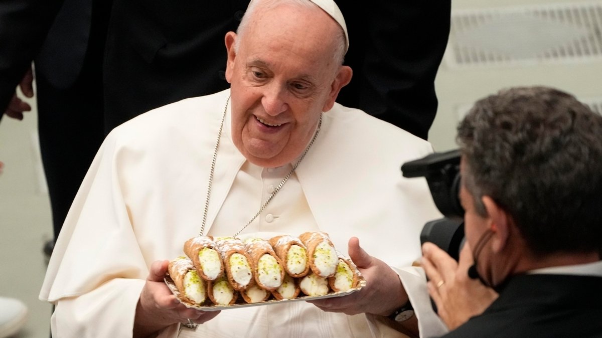 Papst Franziskus erhält am 22.05.2023 im Vatikan ein Tablett mit Cannoli, einem traditionellen sizilianischen Gebäck, während er sich mit Gläubigen der Pilgrimage of the Vocationist Family trifft.
