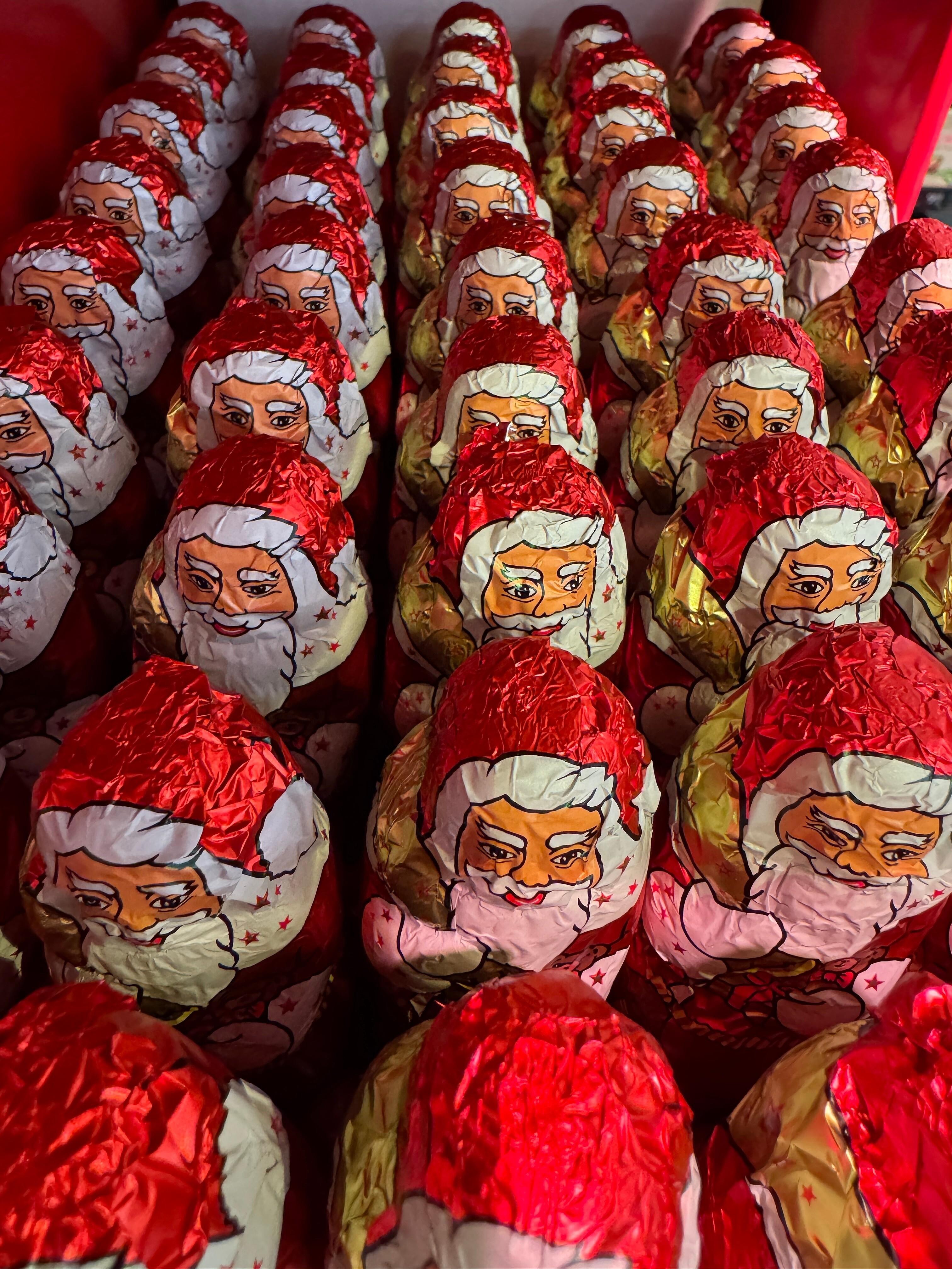 Mehrere Schokonikoläuse stehen nebeneinander in einem Supermarktregal.