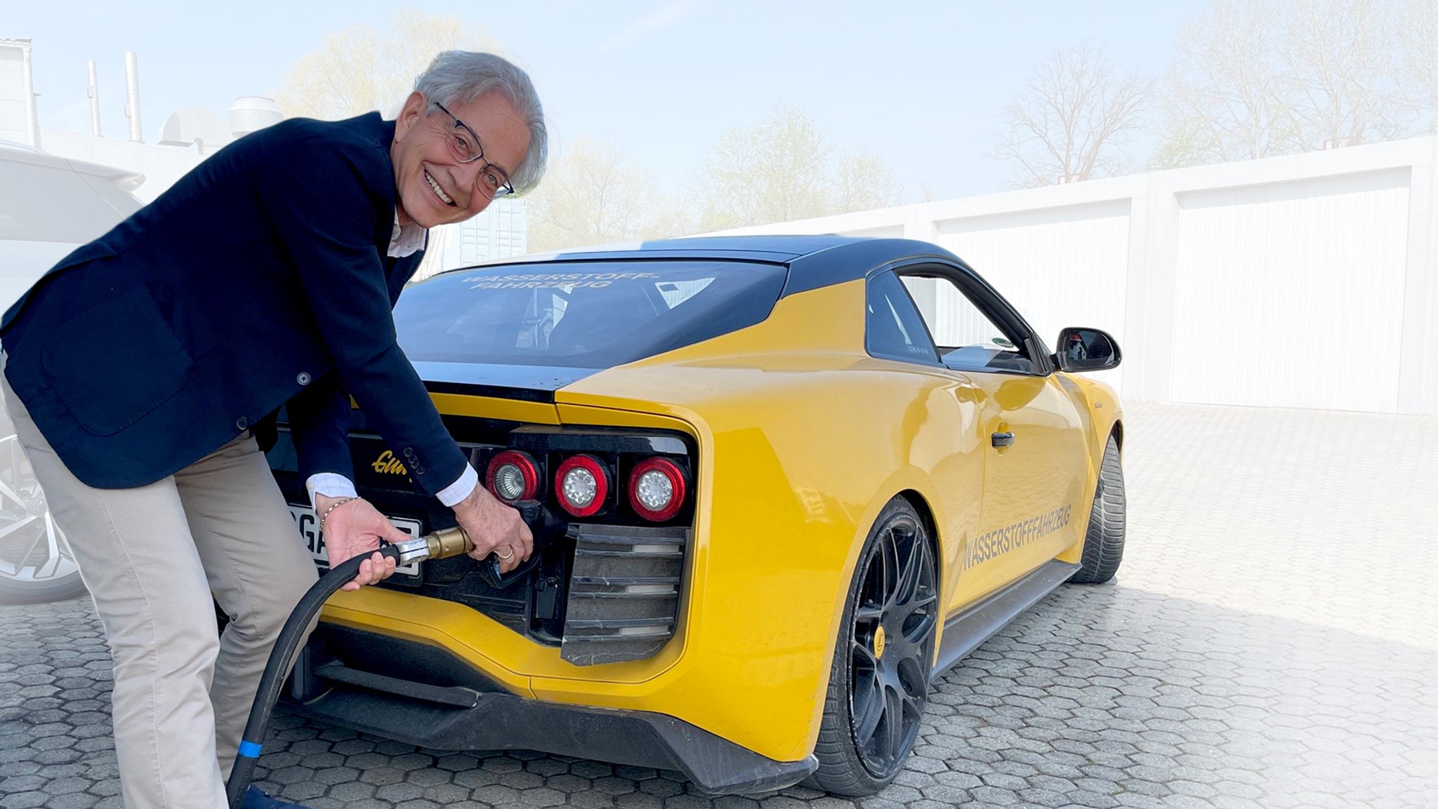 Roland Gumpert tankt sein Elektroauto, das mit einer Methanol-Brennstoffzelle ausgerüstet ist.