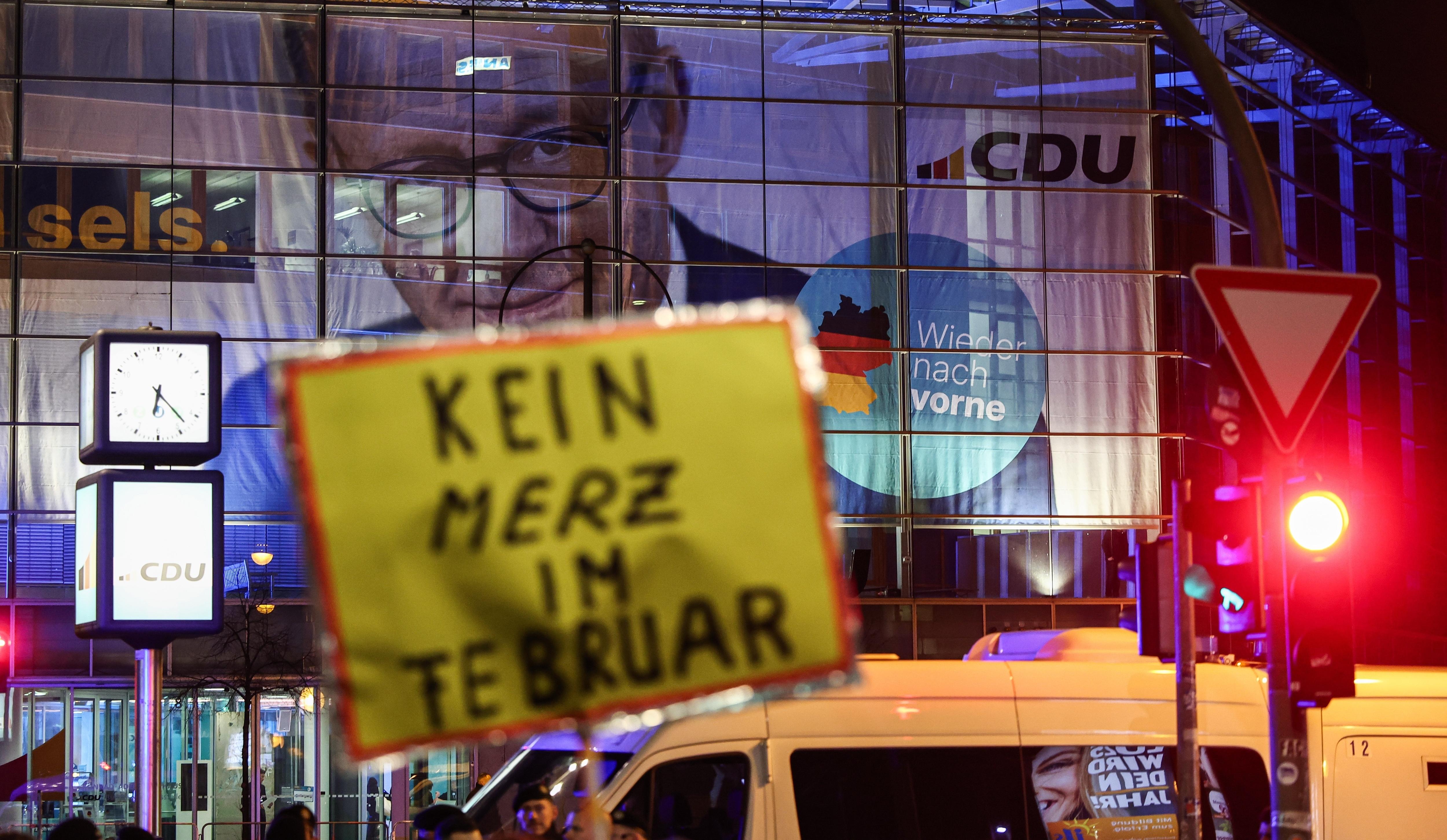 Ein Demonstrant hält ein Schild "Kein Merz im Februar" vor der CDU-Parteizentrale in Berlin. 