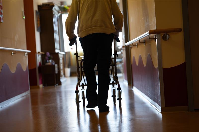 (Symbolbild) Ein älterer Mensch mit Rolator in einem Pflegeheim