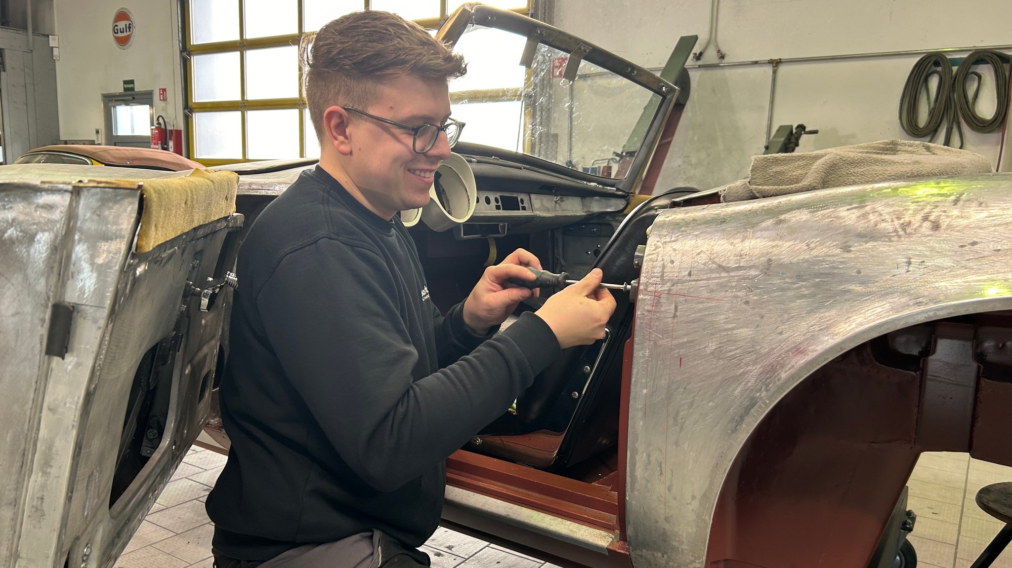 Lukas Effenberger von der Firma Martelleria schraubt an einer Karosserie.