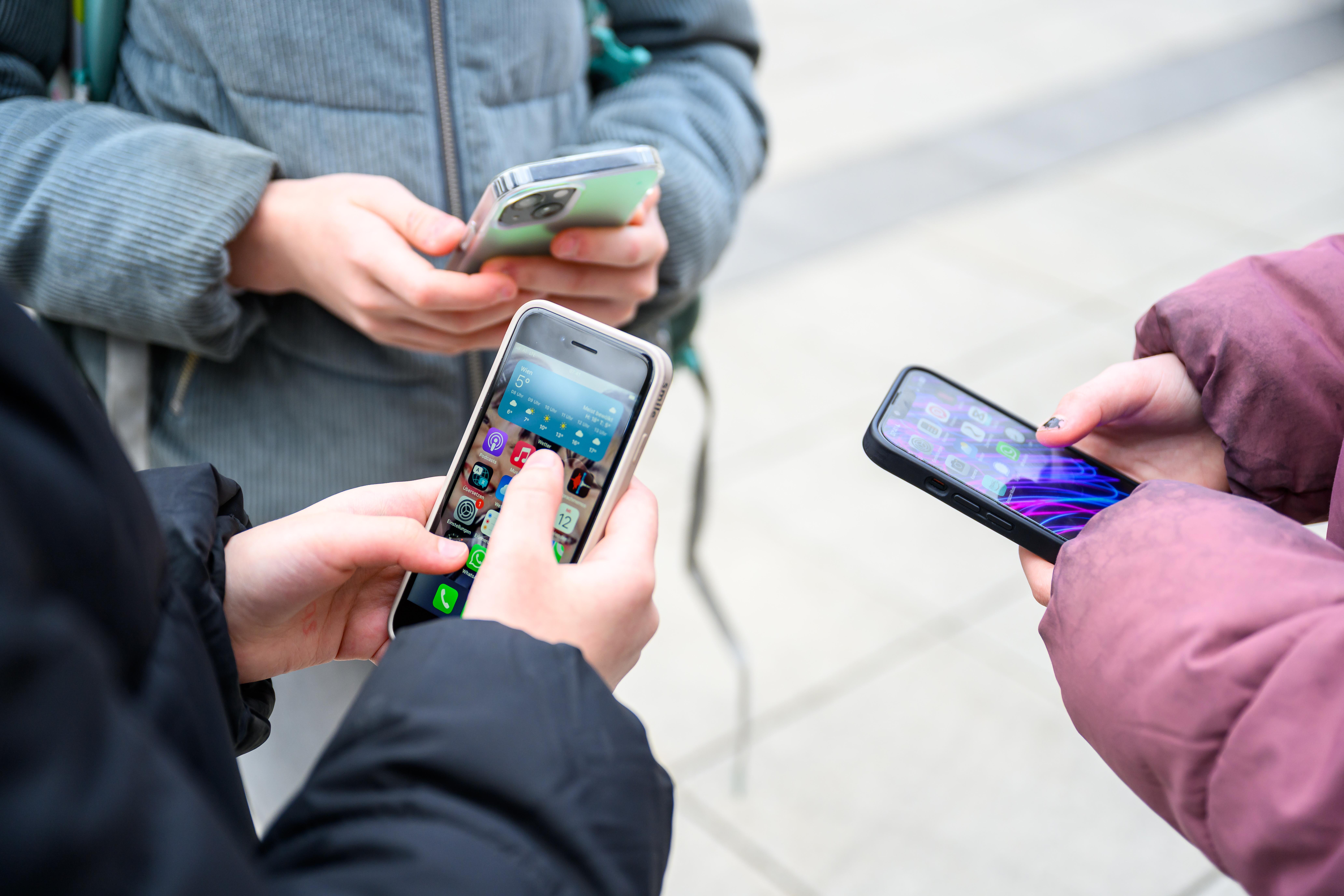 Schülerinnen und Schüler mit Smartphones