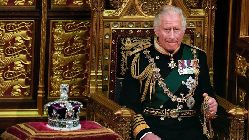 König Charles III. sitzt neben der  Imperial State Crown . 