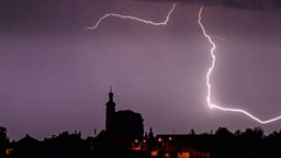 Blitze entladen sich aus einer Gewitterwolke über einer Kirche in Niederbayern (Archivbild). | Bild:dpa-Bildfunk/Armin Weigel