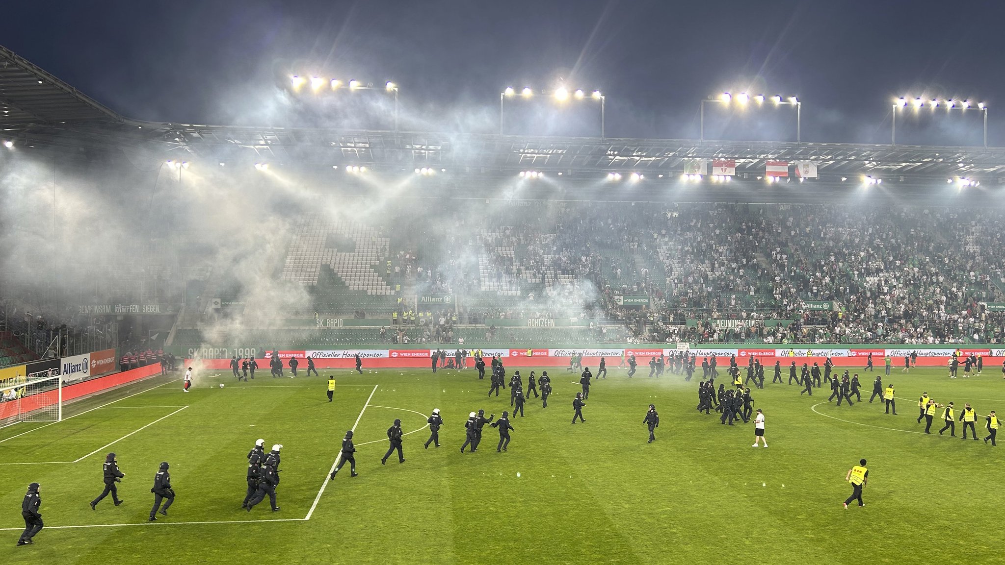 Polizeikräfte stürmen den Fußballplatz im Wiener Allianz Stadion.