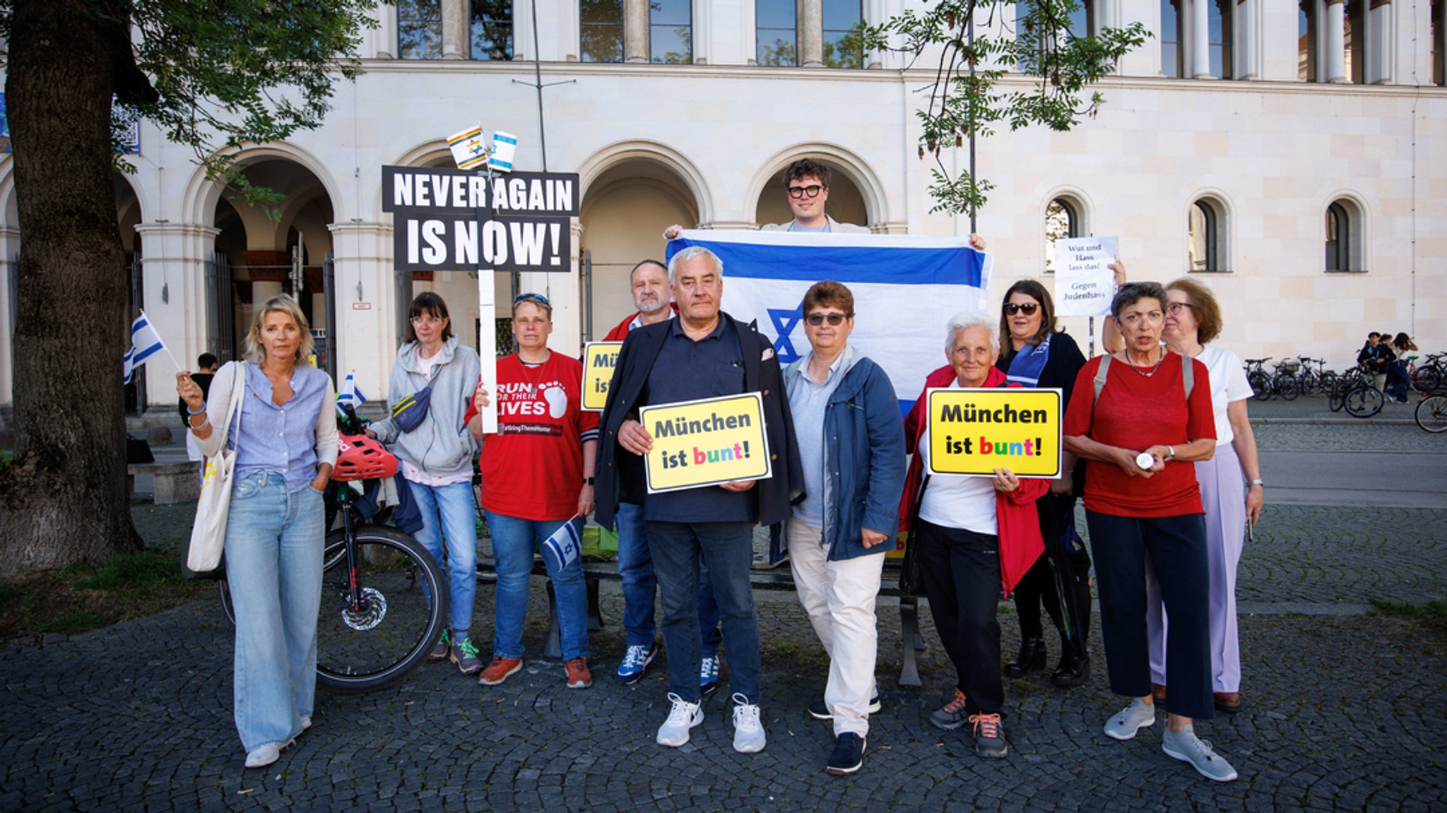 Ludwig Spaenle (M)  zwischen Teilnehmern einer Mahnwache gegen ein geplantes Pro-Palästina-Protestcamp vor der Ludwig-Maximilians-Universität.