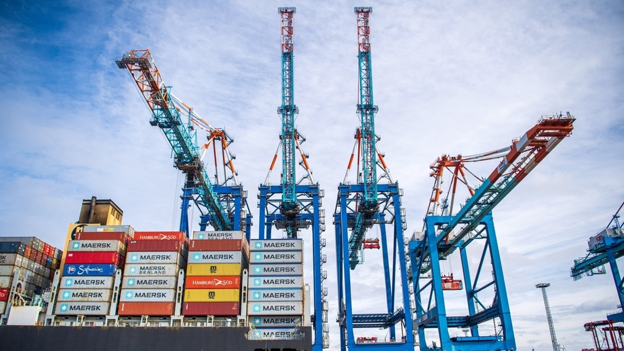 Ein Schiff liegt im Containerhafen Bremerhaven, im Hintergrund die Be- und Entladekräne.