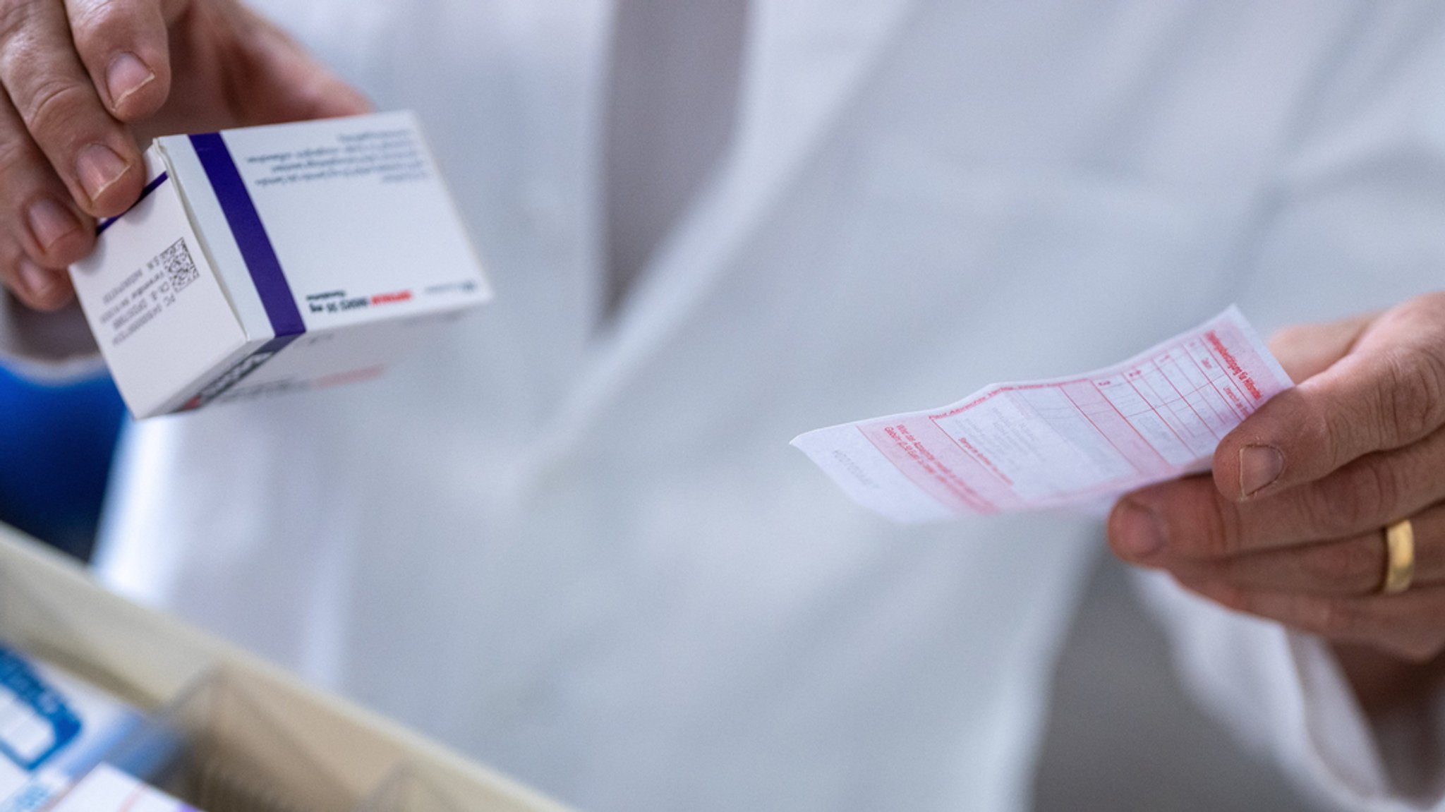 Medikamente (Symbolbild): Ein Apotheker hält ein Rezept in der Hand.