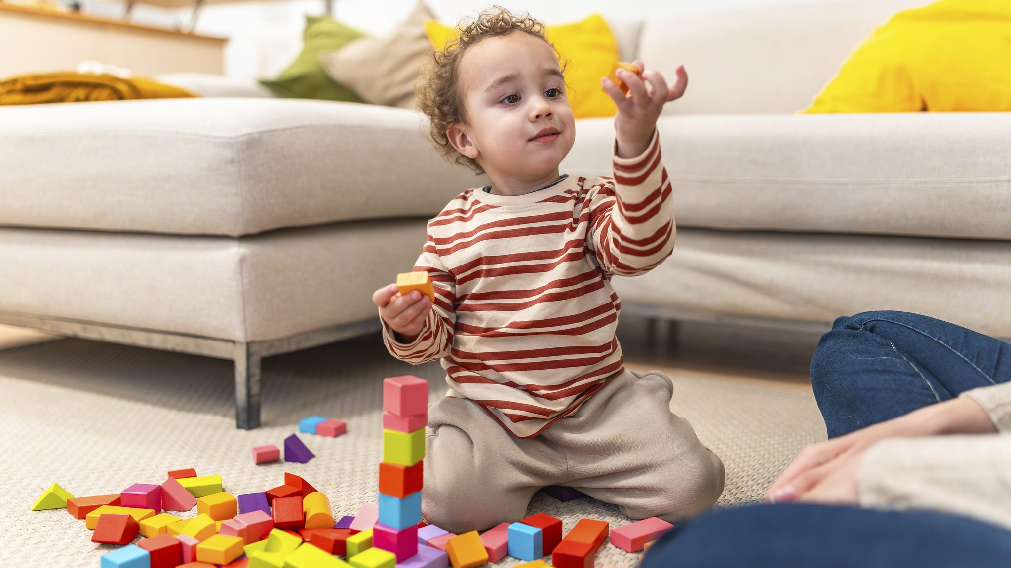 Feinmotorik fördern bei Kindern: Das Bauen mit Holzklötzen trainiert Feinmotorik, Fingerfertigkeit, Hand-Auge-Koordination und Konzentration.
