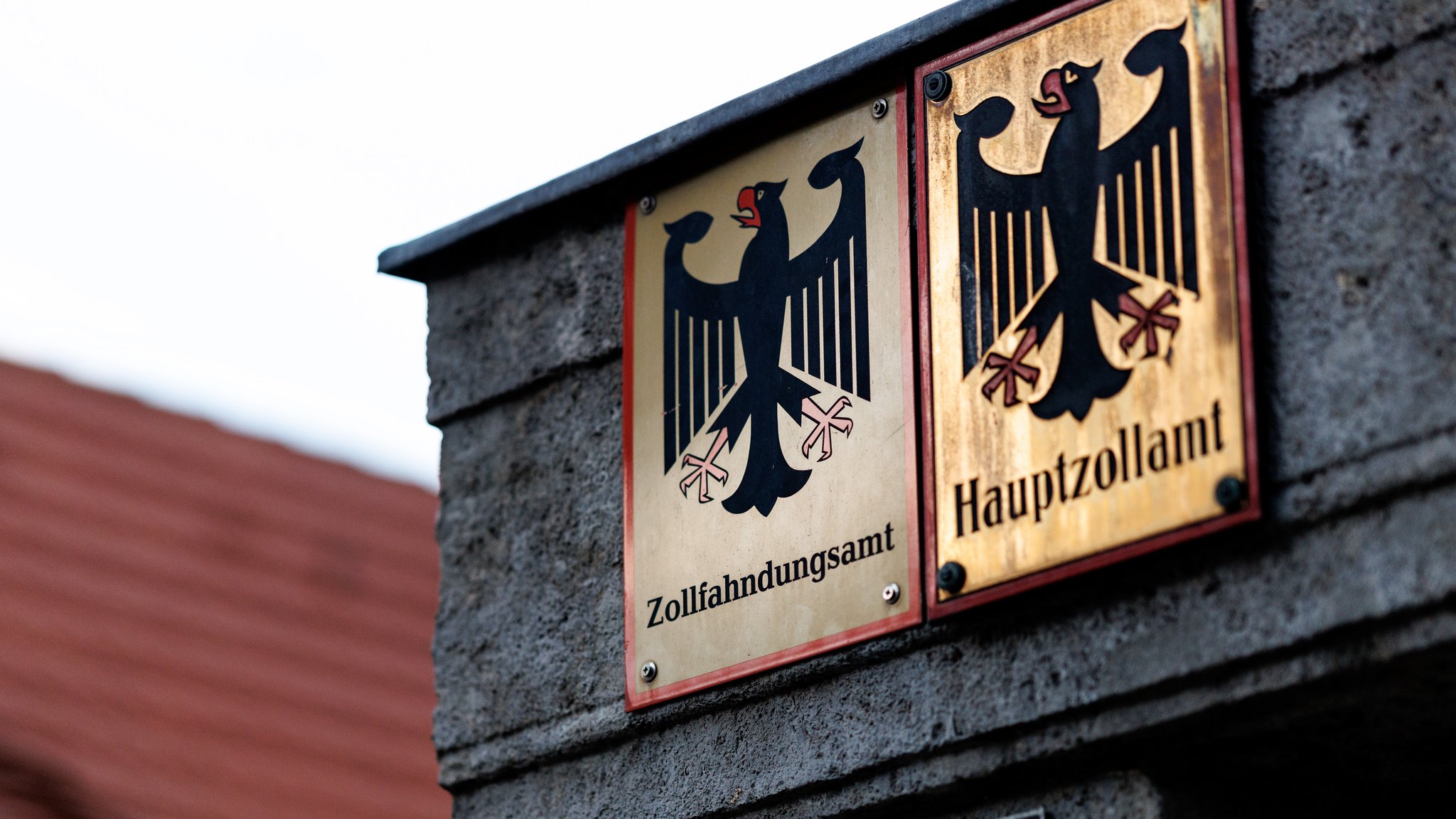 Symbolbild: Ein Schild mit dem Bundesadler sowie dem Schriftzug Zollfahndungsamt. 