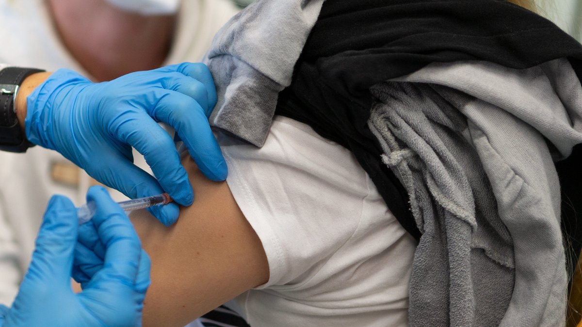 Bei einem Impftermin wird eine Impfdosis mit einem Impfstoff gegen das Coronavirus mit Hilfe einer Impfspritze in den Arm gespritzt.