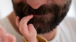 Baby fasst Vater in den Bart | Bild:dpa-Bildfunk/Sebastian Gollnow
