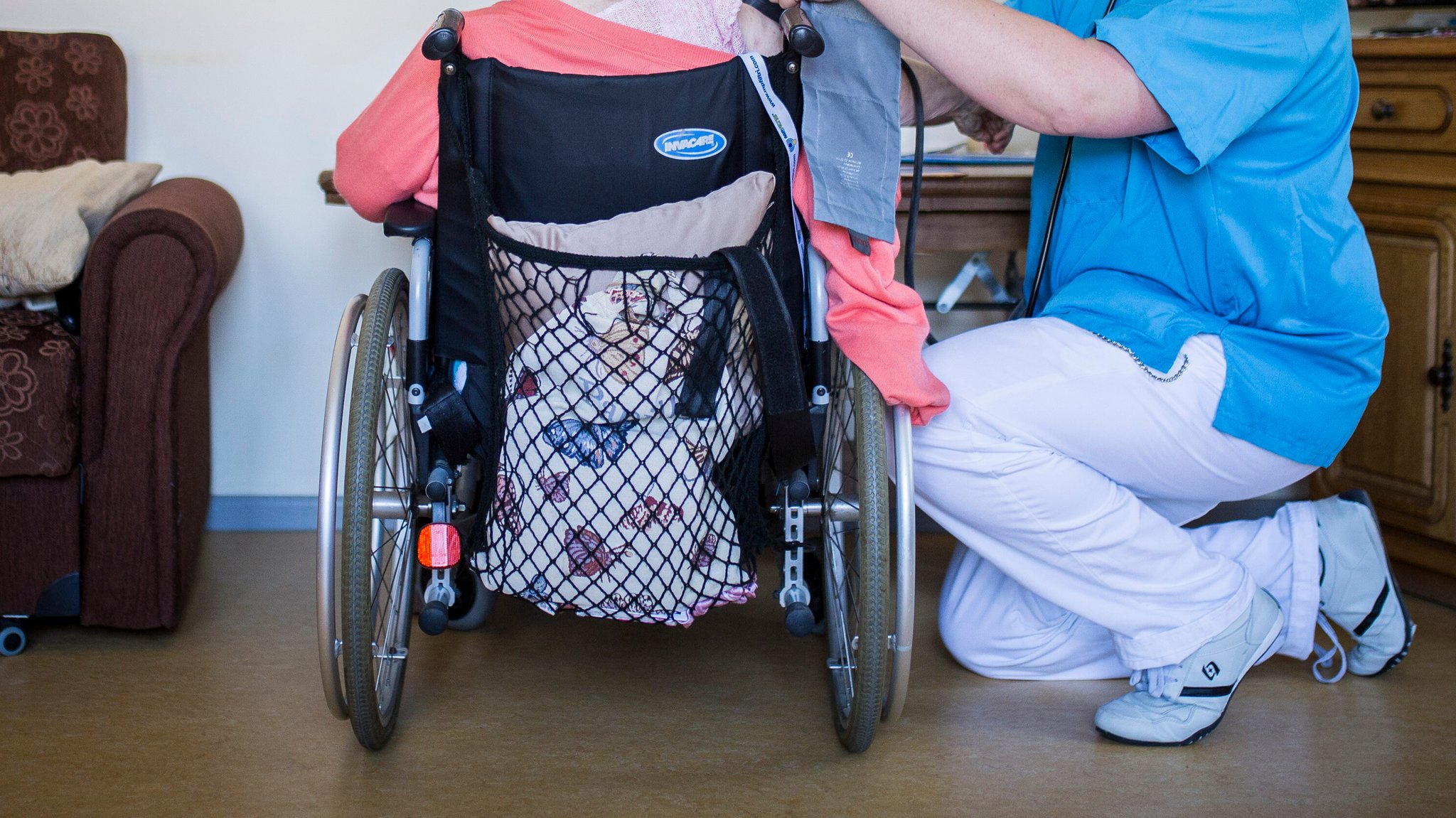 Symbolbild: Eine Pflegekraft misst Blutdruck bei einer Frau im Rollstuhl | Bild: picture alliance / photothek | Florian Gaertner Symbolbild: Eine Pflegekraft misst Blutdruck bei einer Frau im Rollstuhl