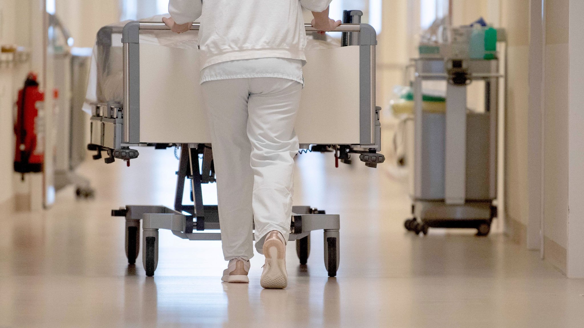 ARCHIV - 20.01.2020, Baden-Württemberg, ---: Eine Krankenpflegerin schiebt ein Krankenbett durch einen Krankenhausflur. (zu dpa: «Neue Kliniken bekommen nicht flächendeckend Klimaanlagen») Foto: Marijan Murat/dpa +++ dpa-Bildfunk +++ | Bild: dpa-Bildfunk/Marijan Murat ARCHIV - 20.01.2020, Baden-Württemberg, ---: Eine Krankenpflegerin schiebt ein Krankenbett durch einen Krankenhausflur. (zu dpa: «Neue Kliniken bekommen nicht flächendeckend Klimaanlagen») Foto: Marijan Murat/dpa +++ dpa-Bildfunk +++