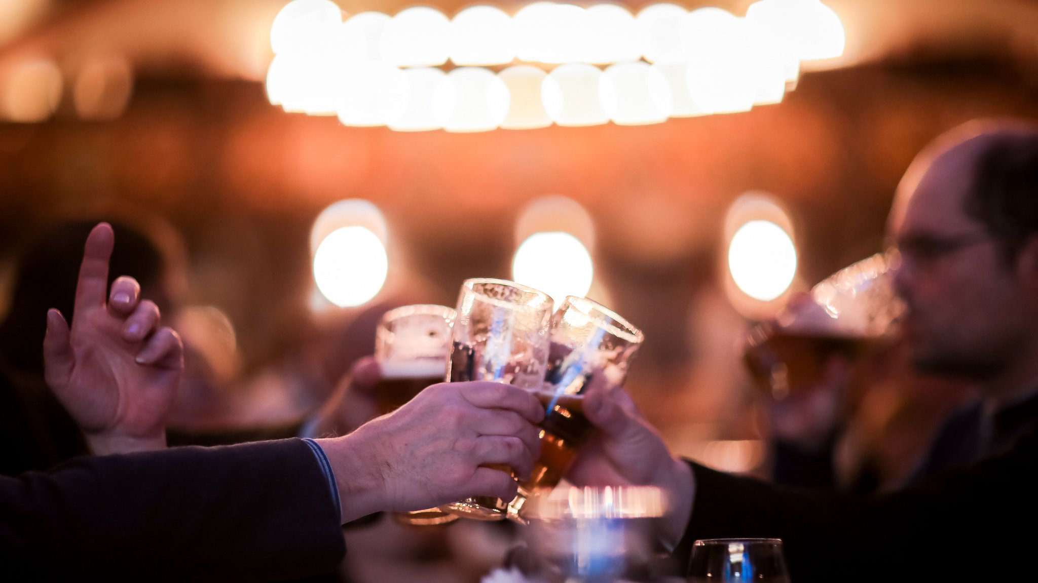 Männer prosten sich mit Bier zu (Symbolbild)