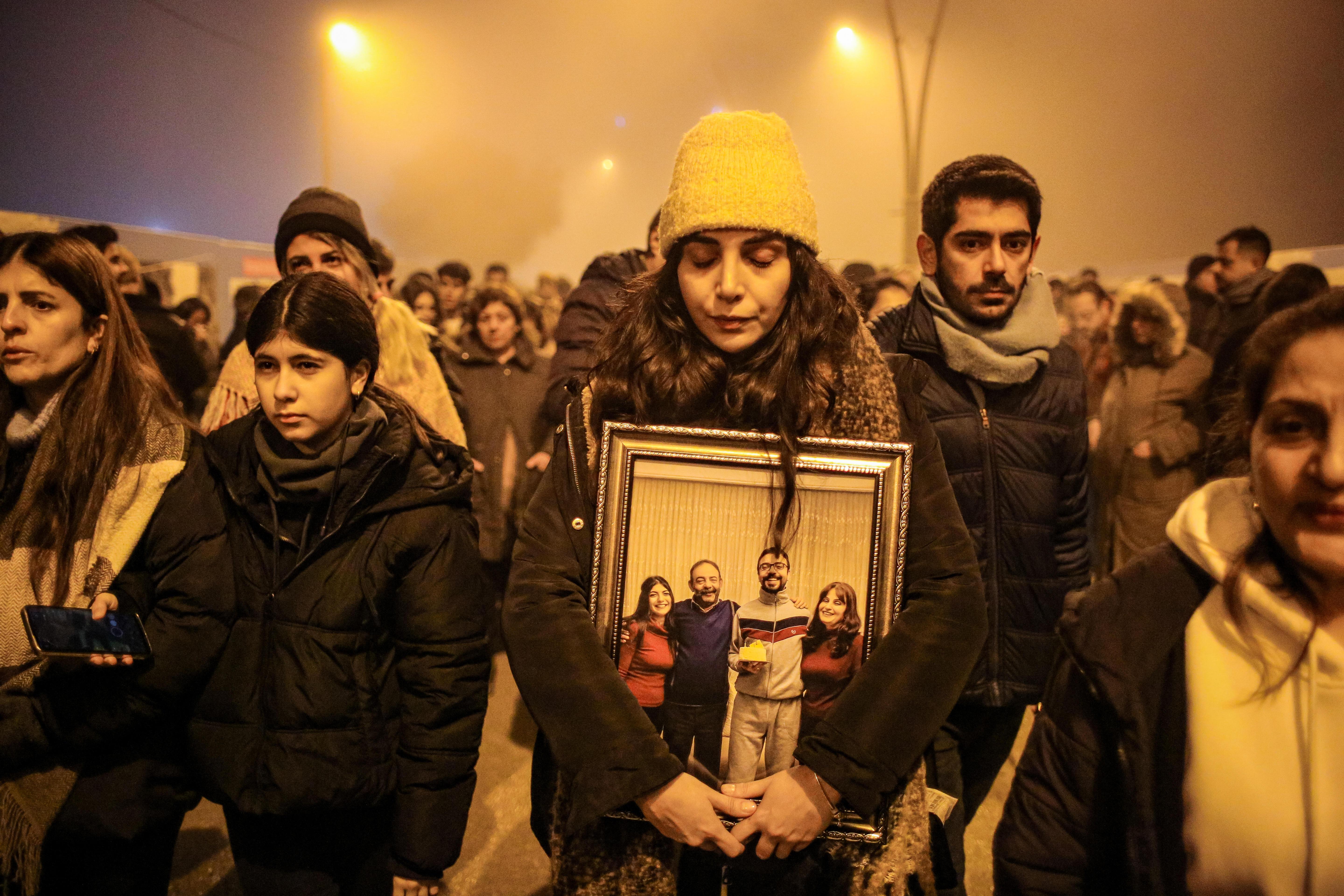 Eine Frau hält beim Gedenken zum Jahrestag der Erdbebenkatastrophe ein Bild von ihren verstorbenen Angehörigen fest umschlossen