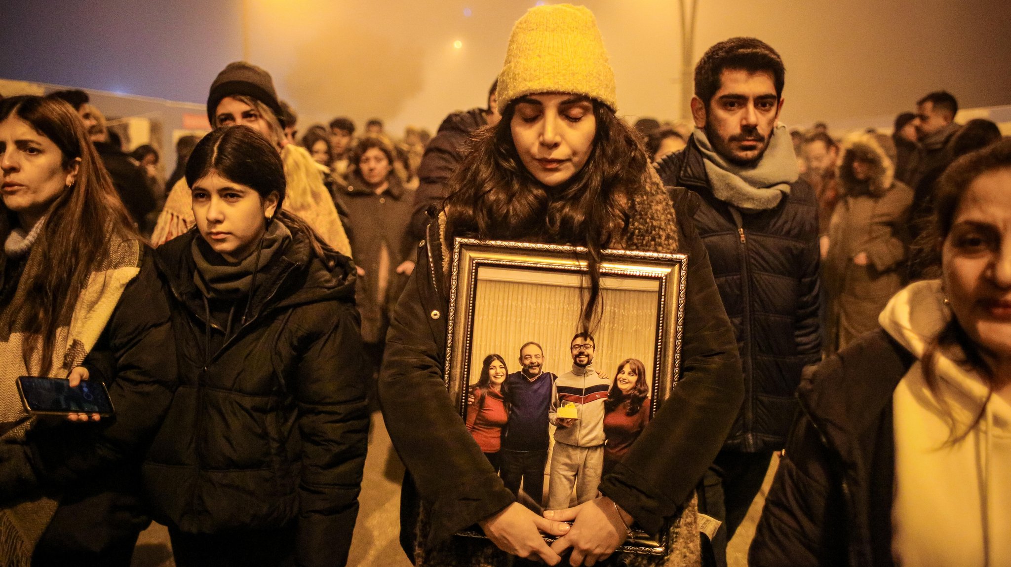 Eine Frau hält beim Gedenken zum Jahrestag der Erdbebenkatastrophe ein Bild von ihren verstorbenen Angehörigen fest umschlossen