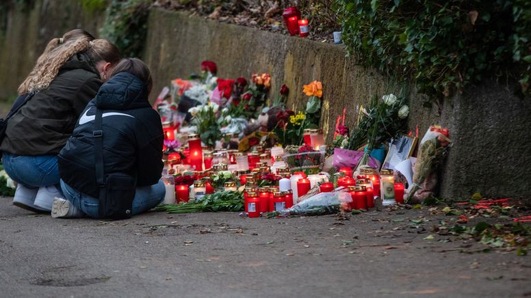 Blumen und Kerzen stehen stehen am Tatort in Illerkirchberg. Mehrere Mädchen knien davor. | Bild:dpa-Bildfunk/Christoph Schmidt