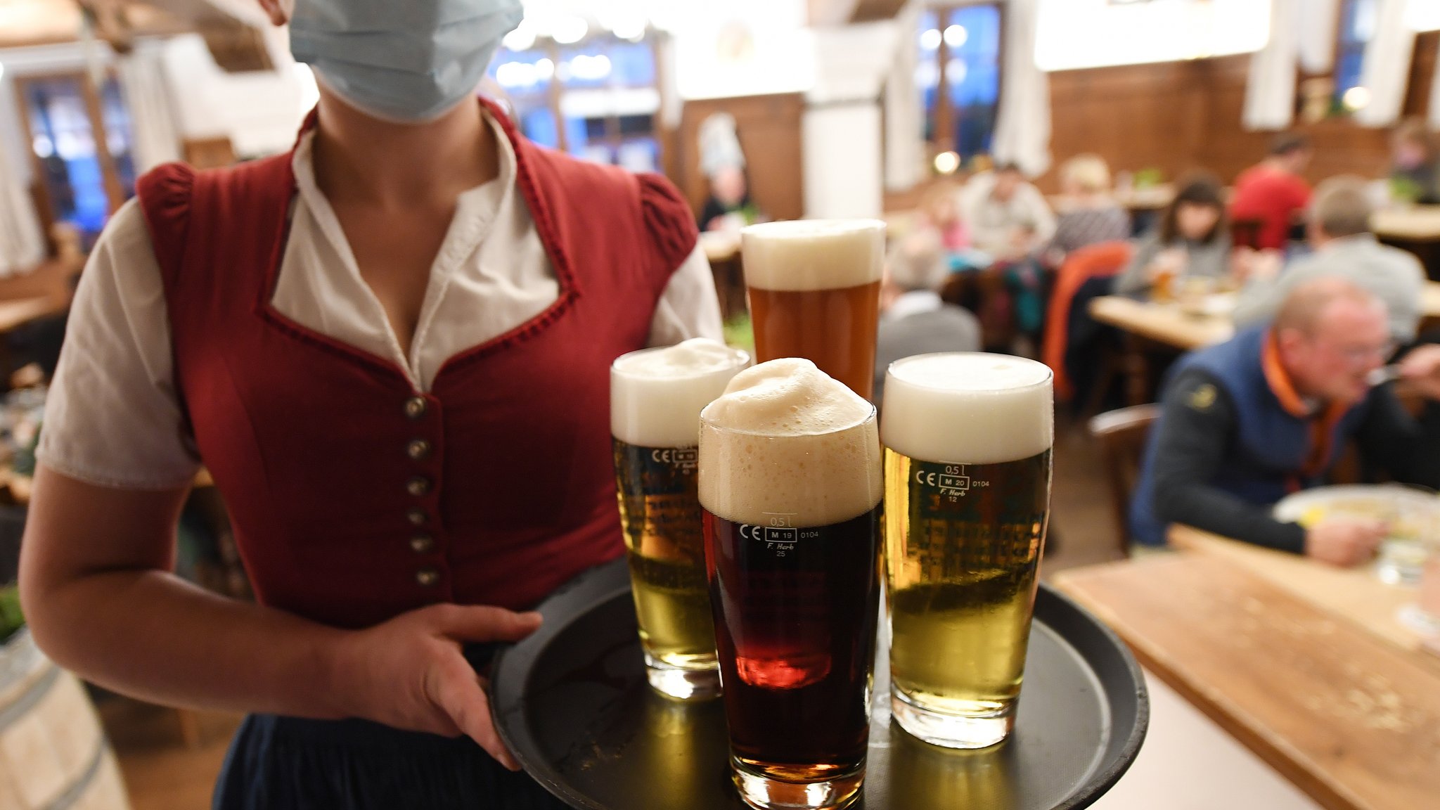 Oktober 2020: Eine Bedienung hält in einem Wirtshaus ein Tablett voll mit Bier (Symbolbild).