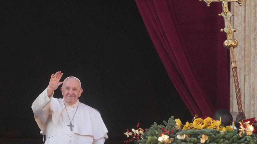 25.12.2022, Vatikanstadt: Papst Franziskus winkt den Gläubigen zu, als er den Weihnachtssegen "Urbi et Orbi" erteilt.