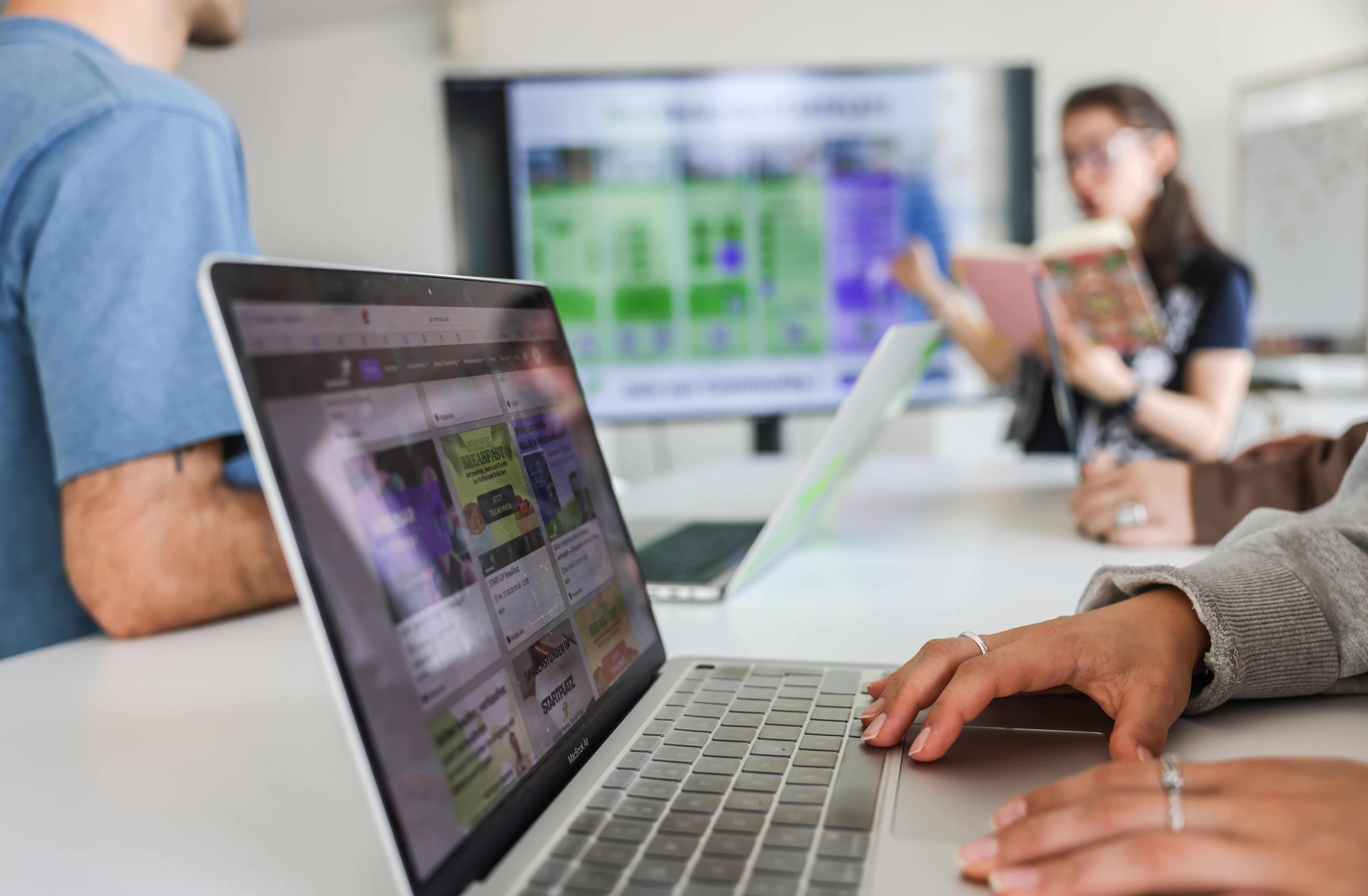 Teilnehmer eines Meeting sitzen an Laptops