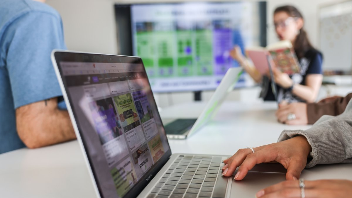 Teilnehmer eines Meeting sitzen an Laptops