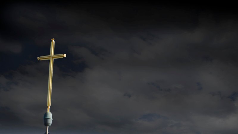 Kreuz und dunkler Himmel, Symbolbild. 