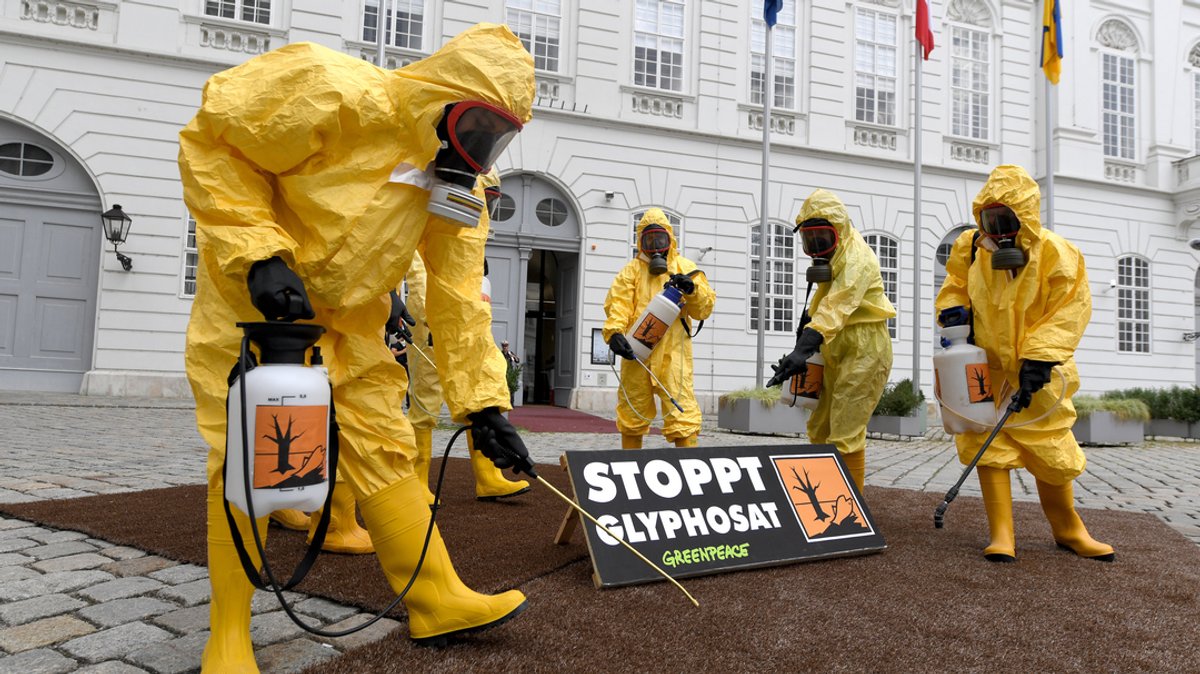 Mitglieder der Umweltorganisation Greenpeace protestieren in gelben Schutzanzügen gegen Glyphosat.