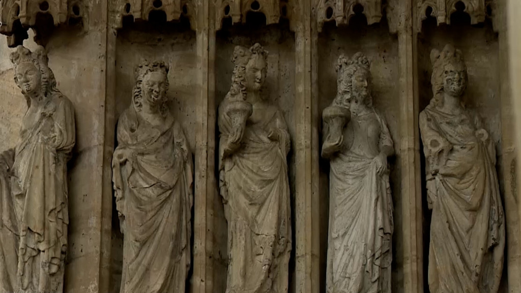 Steinskulpturen von Frauen an der Fassade einer Kirche.