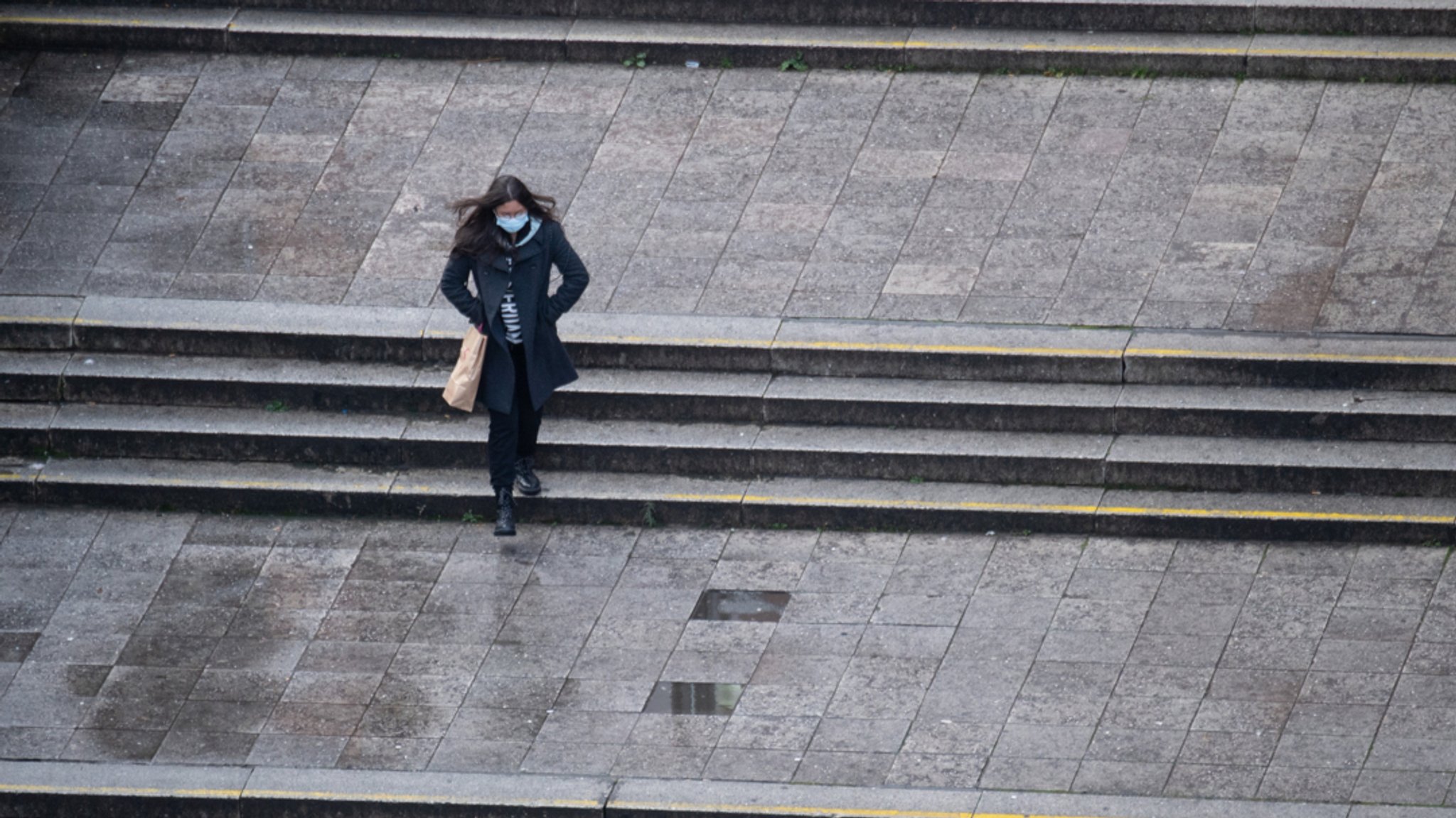 Frankfurt/Main: Eine Frau mit Maske geht allein über die Hauptwache in Frankfurt am Main.