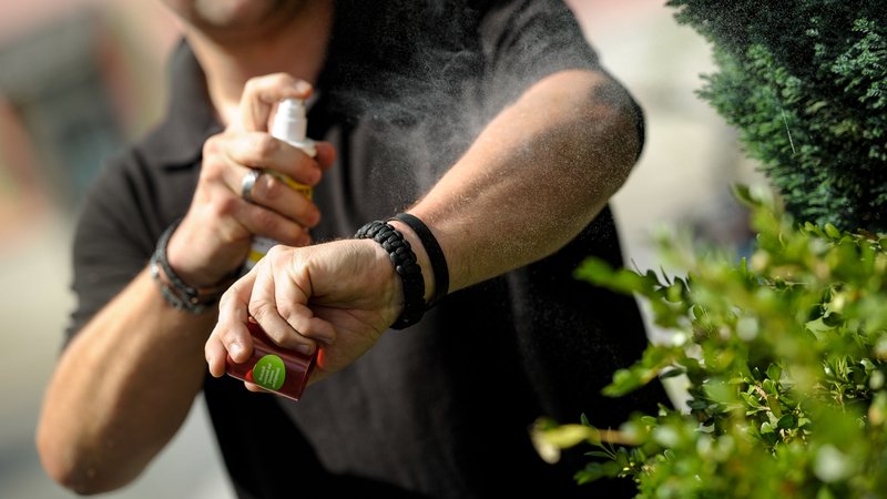 Mann sprüht seinen Unterarm mit einem Mückenschutzmittel ein | Bild: picture alliance / SZ Photo | Alessandra Schellnegger Mann sprüht seinen Unterarm mit einem Mückenschutzmittel ein