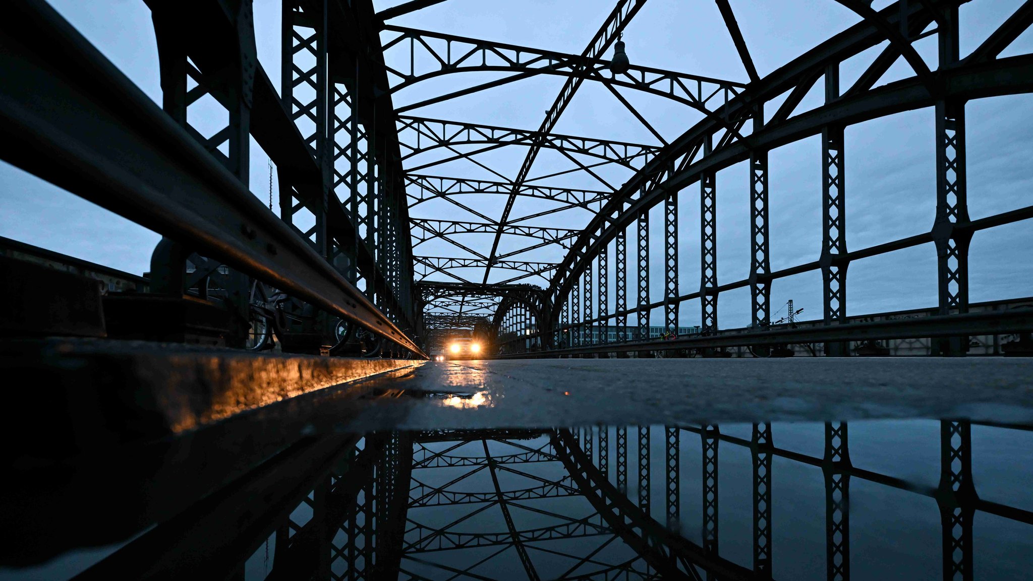 Ein Auto fährt über die Hackerbrücke, auf der sich eine große Pfütze gebildet hat.