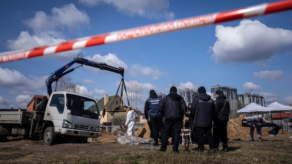 Archivbild: 11.04.2022, Butscha: Gerichtsmediziner und Polizisten untersuchen die Leichen von Anwohnern.  