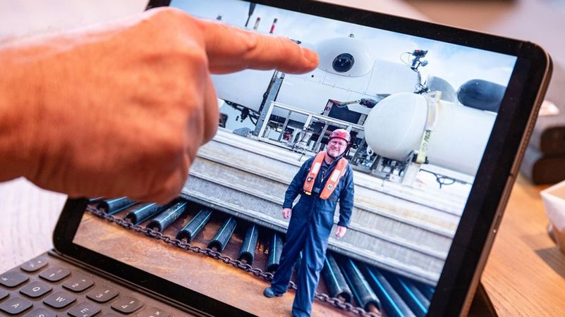 21.06.2023, Bayern, Straubing: Ein Foto auf einem Tablet zeigt Arthur Loibl, einen ehemaligen Passagier der "Titan", vor dem Mini-U-Boot des Anbieters Oceangate Expeditions. 2021 ist Loibl als einer der ersten Passagiere mit dem Mini-U-Boot zur Titanic abgetaucht. 