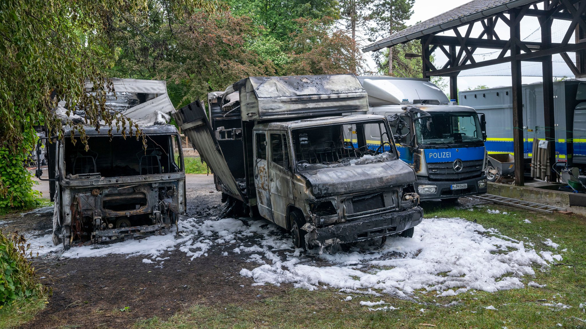 Fahrzeuge der Polizei stehen nach einem mutmaßlichen Brandanschlag auf Polizei-Reiterstaffel auf dem Gelände der Einrichtung. | Bild: picture alliance/dpa | Peter Kneffel Fahrzeuge der Polizei stehen nach einem mutmaßlichen Brandanschlag auf Polizei-Reiterstaffel auf dem Gelände der Einrichtung.