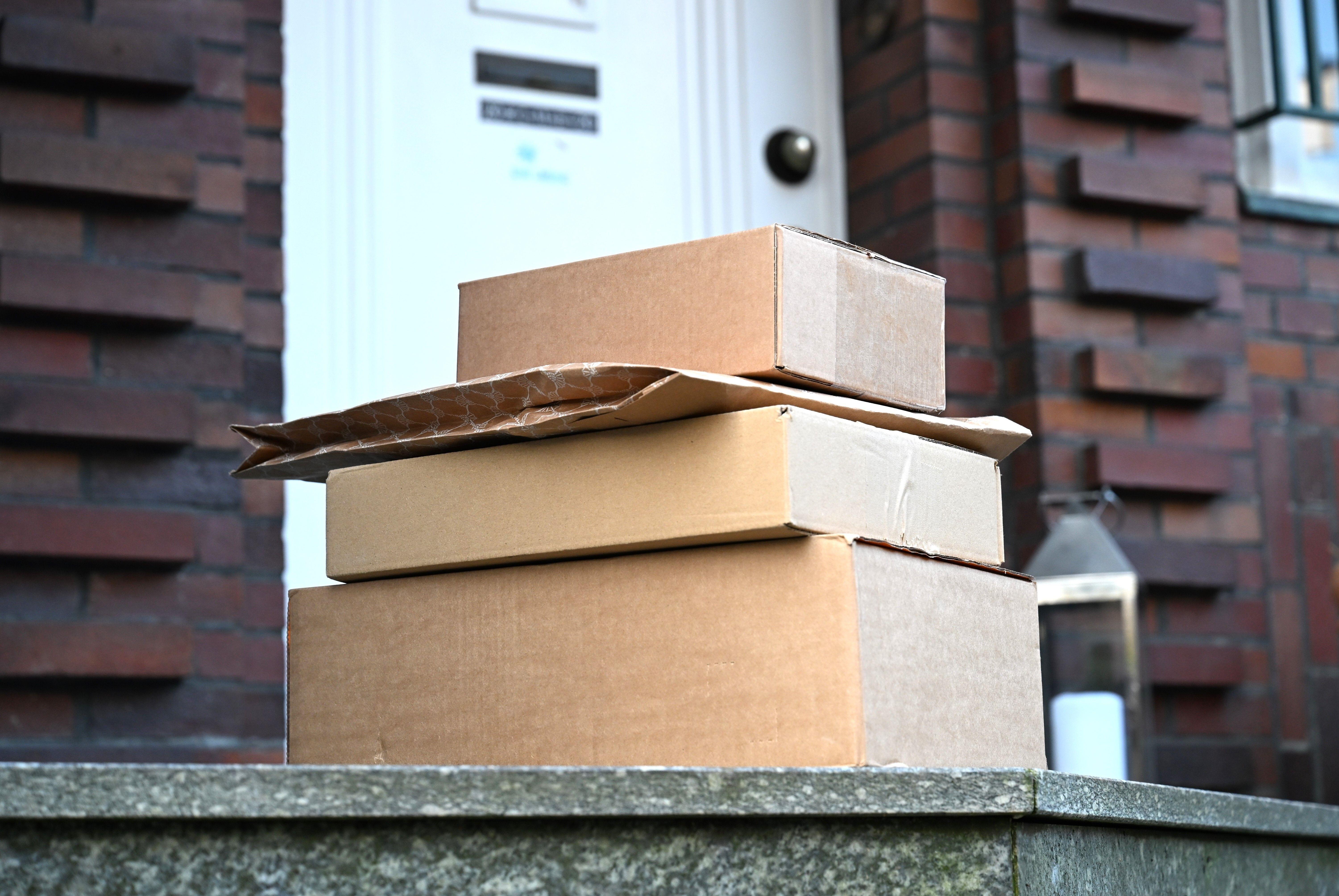 (Symbolbild) Vier Pakete sind vor einer Haustür aufgestapelt