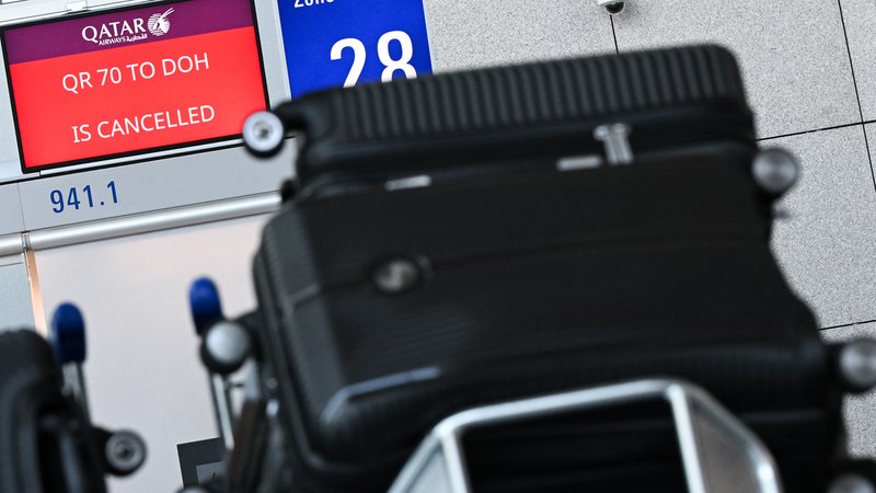 Koffer von Reisenden vor einem Bildschirm, auf dem ein annullierter Flug von Qatar Airways angezeigt wird. | Bild: pa/dpa | Florian Wiegand Koffer von Reisenden vor einem Bildschirm, auf dem ein annullierter Flug von Qatar Airways angezeigt wird.