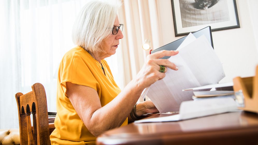 Eine Rentnerin sitzt an ihrem Schreibtisch und sortiert Belege für die Steuererklärung. | Bild:picture alliance / dpa-tmn | Christin Klose