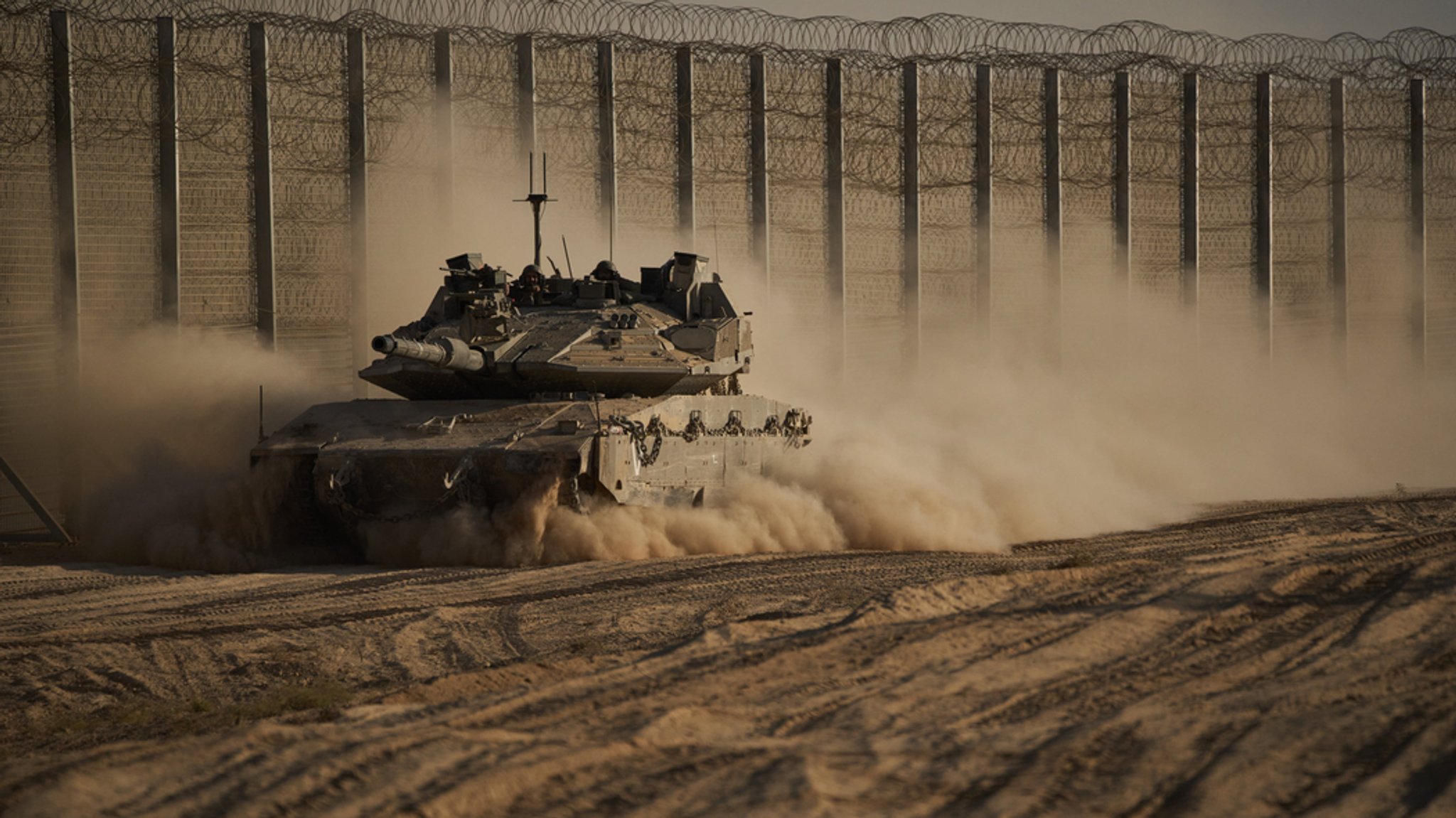 21.10.2025, Israel, ---: Israelische Soldaten bewegen sich mit einem Panzer entlang der Grenze zwischen Israel und Gaza, gesehen vom Süden Israels aus. 