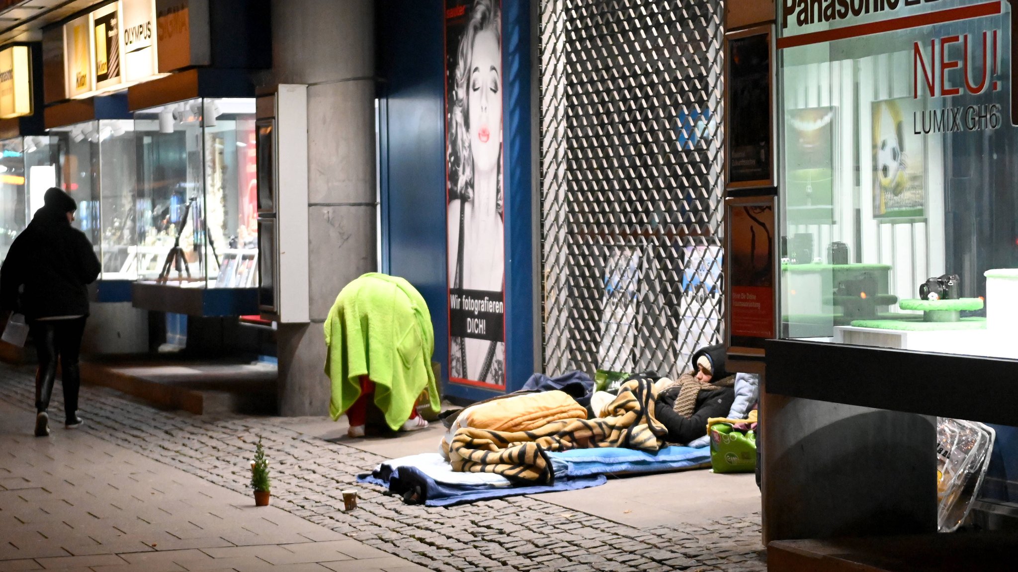 Obdachlose in einem Bürogebäude-Eingang auf der Münchner Sonnenstraße. Wie übersteht man Winternächte, wenn man keine Wohnung hat? In München versucht die "Aktion Brücke" die Not der Obdachlosen zu lindern.