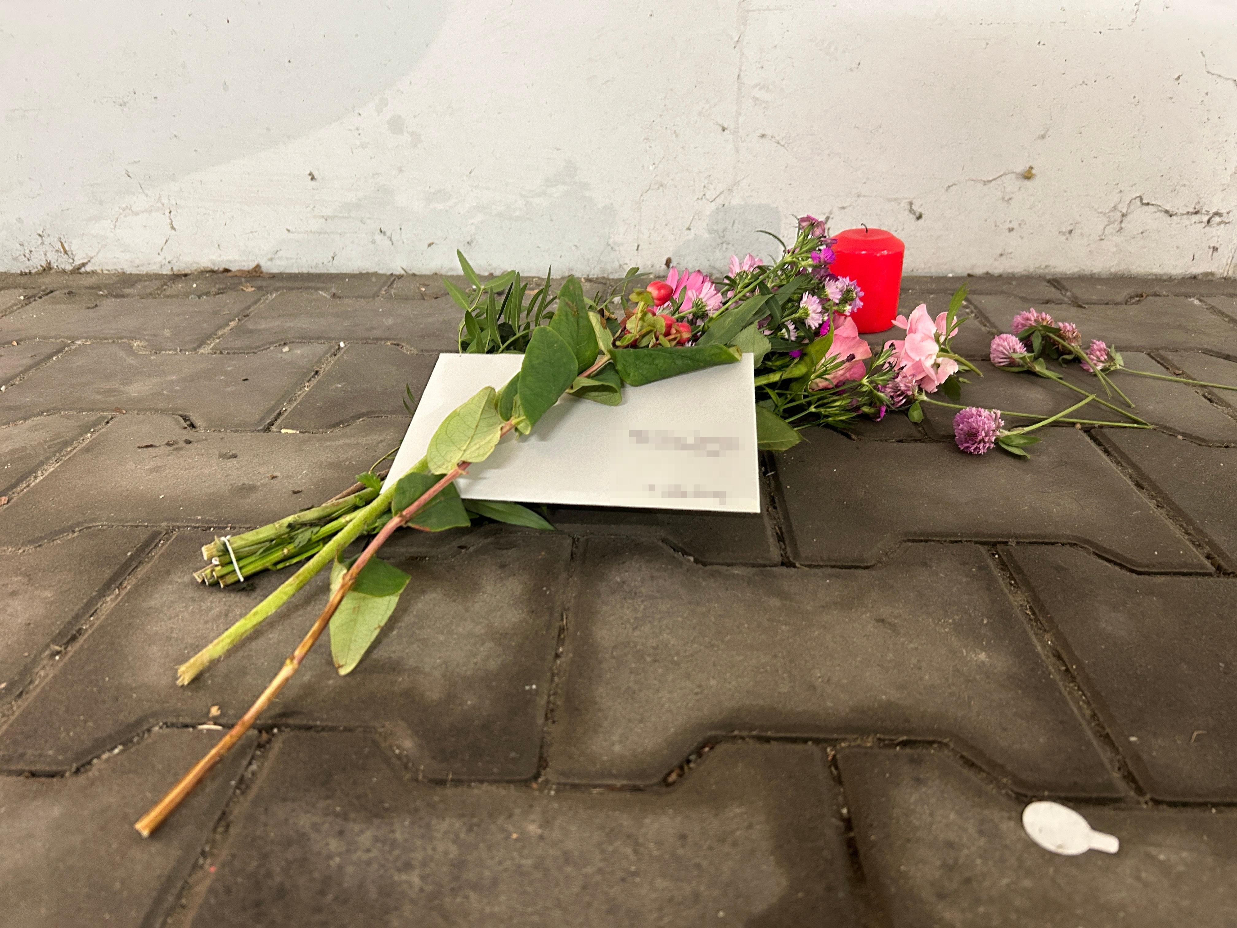 Vor die Tiefgarage haben Menschen Blumen und Kerzen gelegt. 