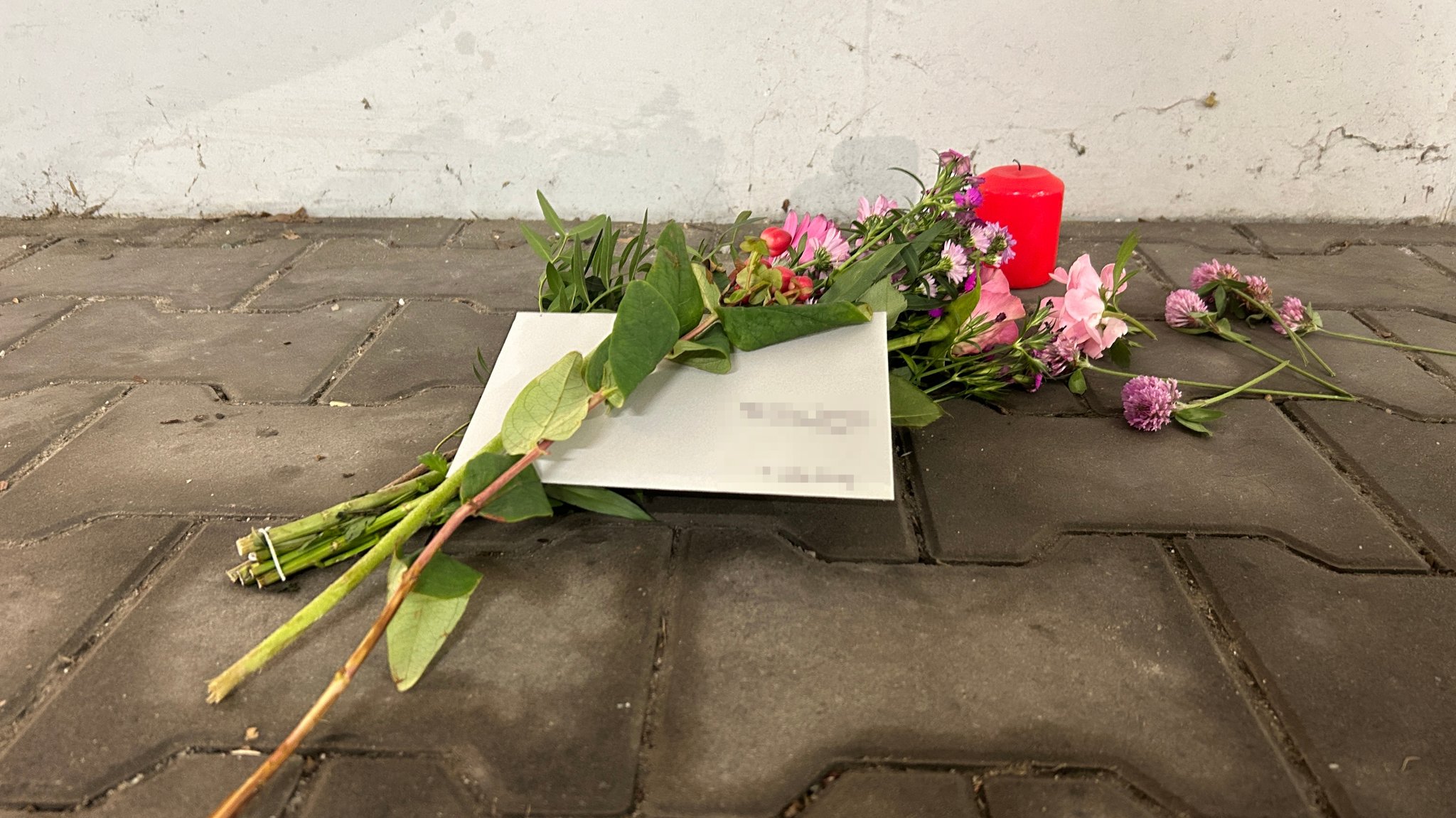 Vor die Tiefgarage haben Menschen Blumen und Kerzen gelegt. 